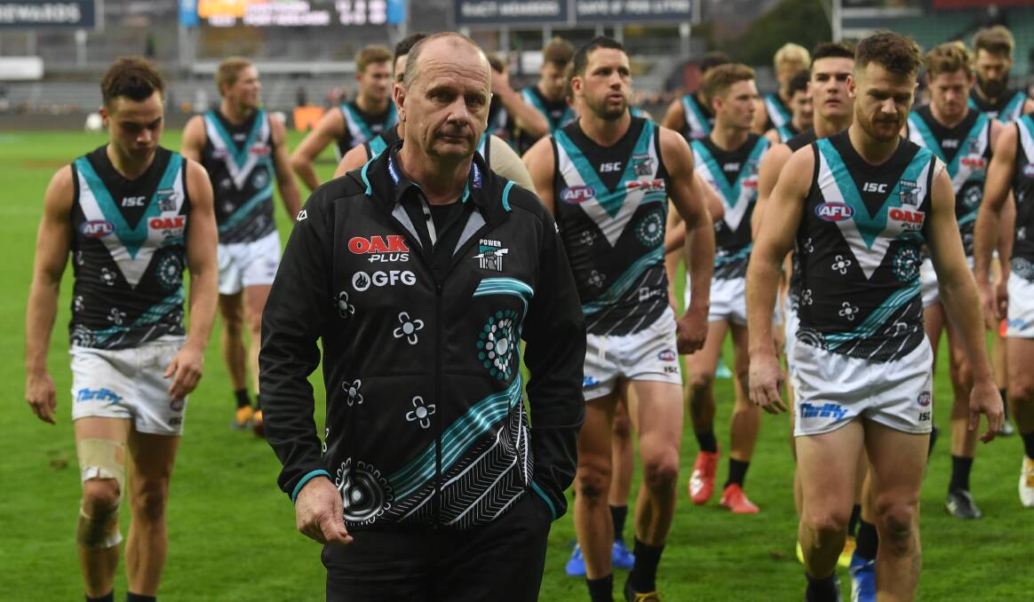 A disappointed Ken Hinkley leads his players off the ground. 