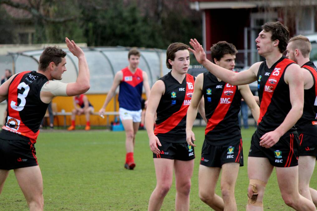 TEAMING UP: Whitford and Callow wind up for a high-five against North Hobart last year. Picture: Hamish Geale 