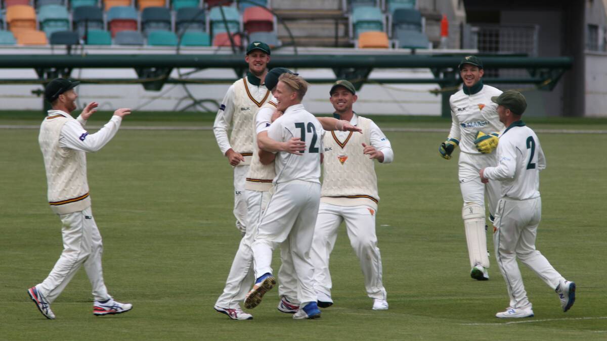 GET AROUND HIM: Nathan Ellis is swamped by teammates after picking up a fifth second-innings wicket. Pictures: Rick Smith 