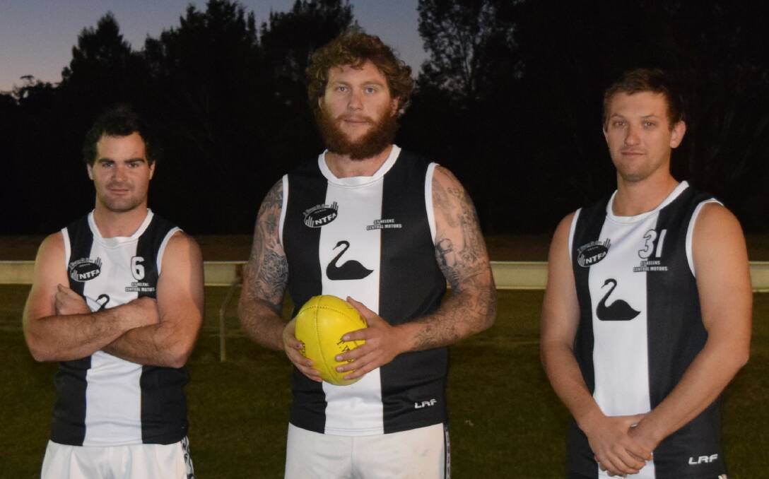 BLACK AND WHITE: East Coast's Wade Garth, Ned Hyland and Kenneth Reid model the retro guernseys the Swans will wear in Saturday's clash at Pyengana. Picture: Supplied