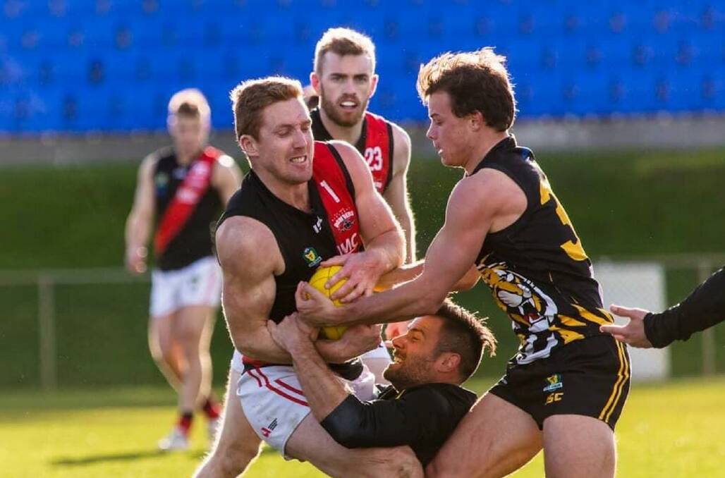 ARM WRESTLE: Brad Cox-Goodyer finds himself in a tangle with two Kingborough opponents. Picture: Solstice Digital 