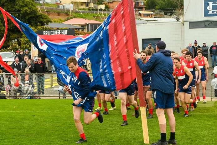 BREAK THE BANNER: Lilydale run through the banner on grand final day.