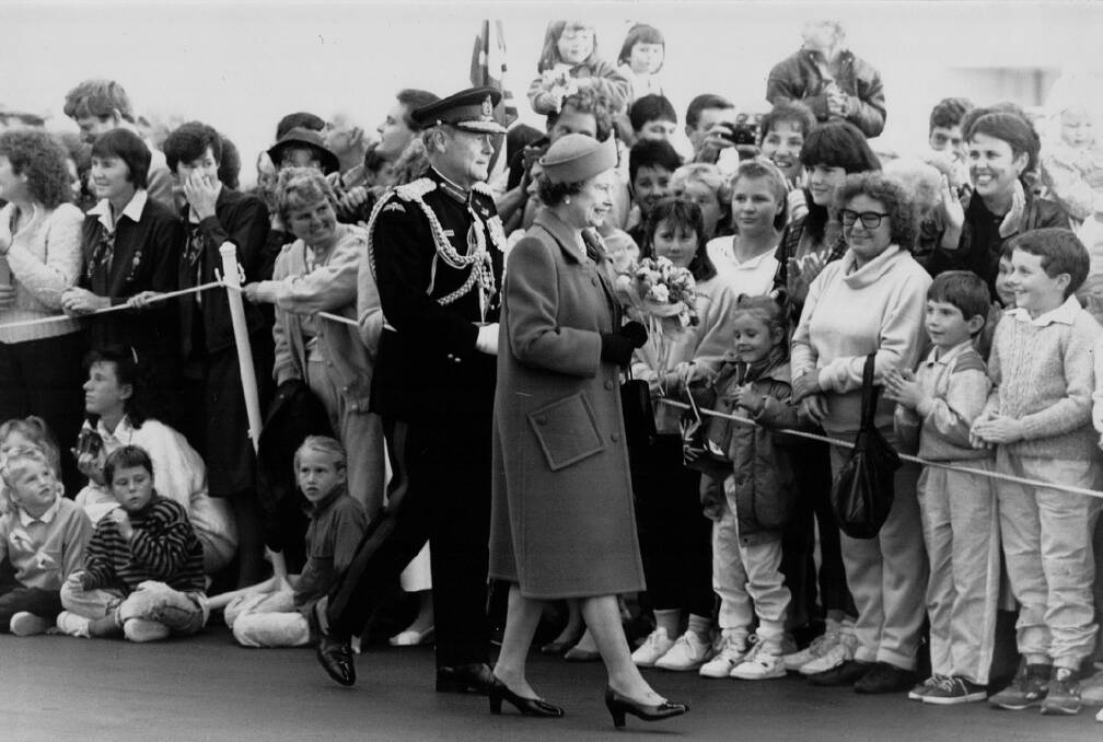 Governer of Tasmania Sir Phillip Bennett escorts the Queen past crowds waiting to welcome her at Hobart airport during Queen Elizabeth and Prince Philip's 1988 royal visit. File picture 