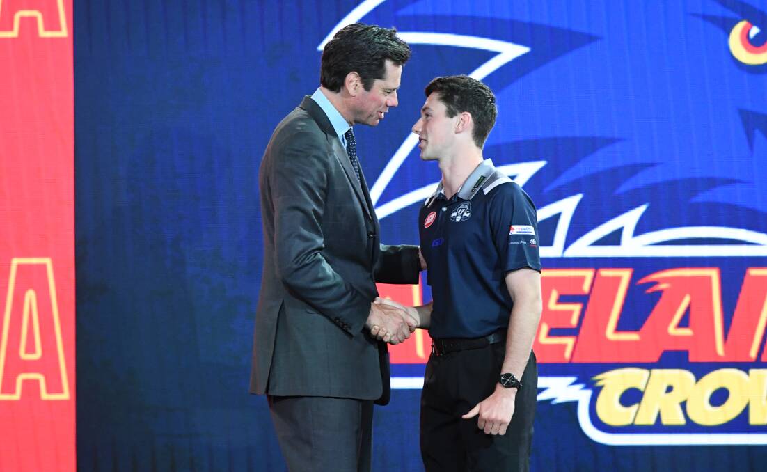 Chayce Jones shakes hands with AFL chief executive Gillon McLachlan. 