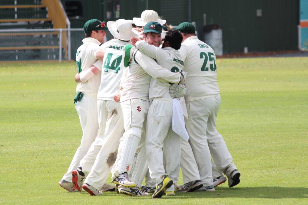 DONE IT: Launceston skipper Alistair Taylor embraces teammates after picking up the final Riverside wicket. Picture: Hamish Geale 