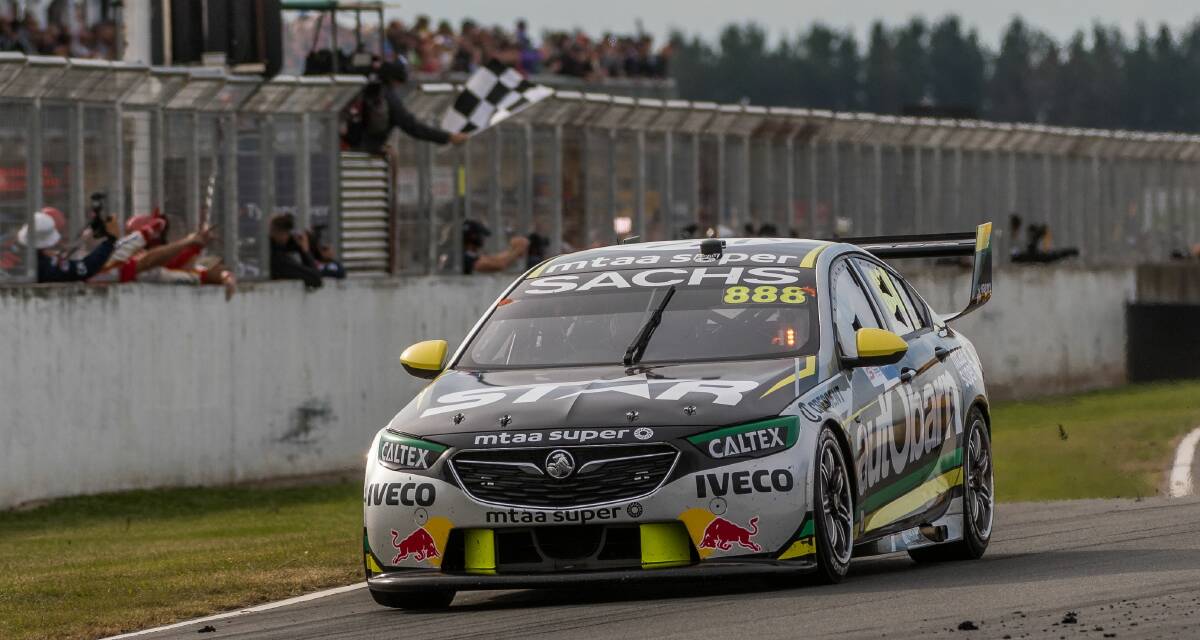 STILL GOT IT:  Supercars icon Craig Lowndes receives the chequered flag after crossing the line first for his eighth race win at Symmons Plains. Picture: Phillip Biggs
