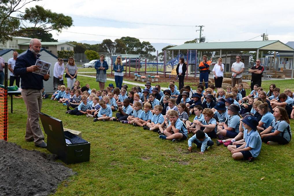 PRESERVING HISTORY: Bicheno Primary School principal Brodie Philip prepares the time capsule as students and staff look on. Pictures: Supplied 