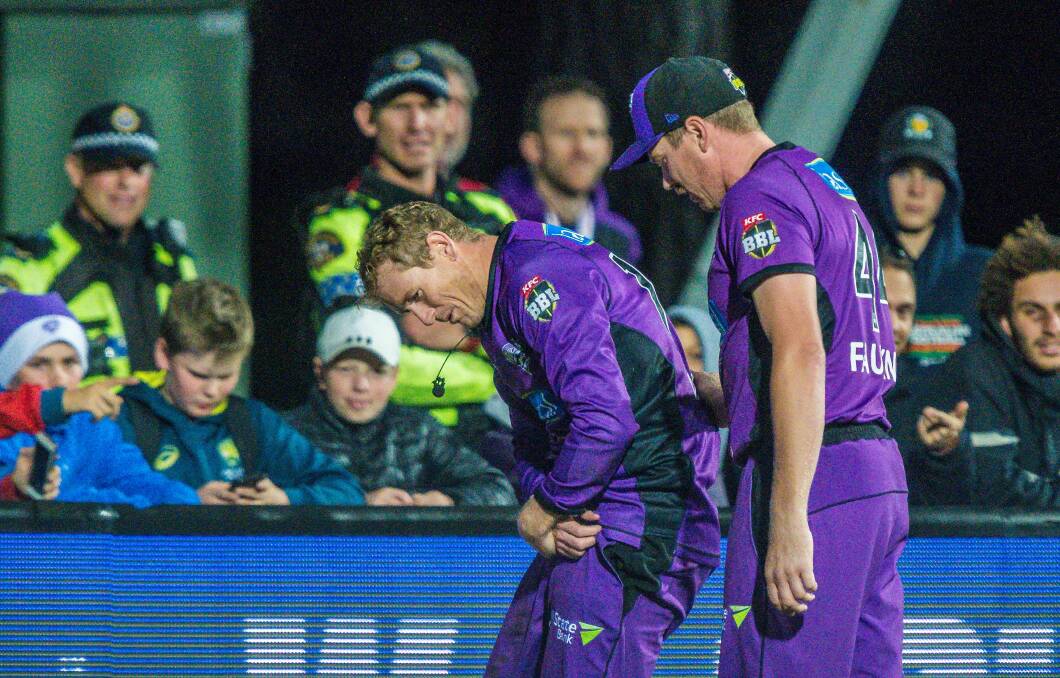 BATTLE-SCARRED: George Bailey walks off nursing a dislocated shoulder with Hurricanes teammate James Faulkner in tow. Picture: Phillip Biggs