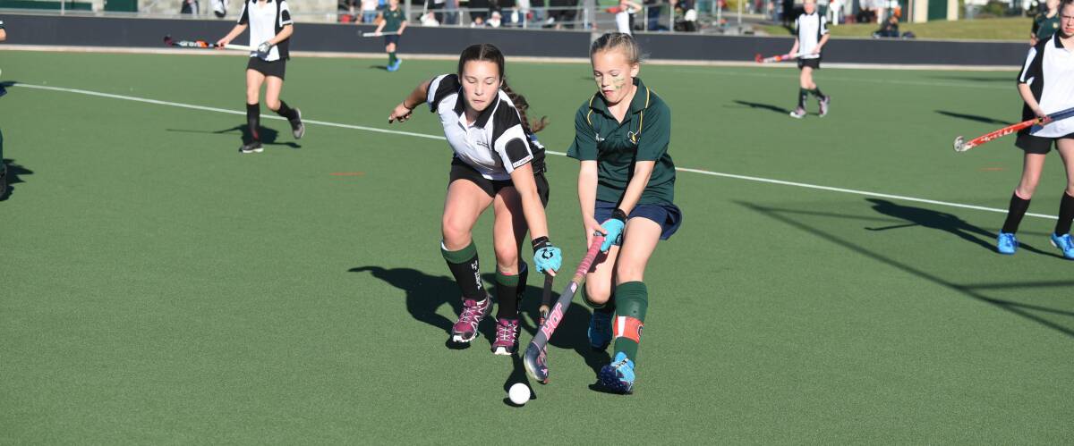 STICKY SITUATION: Northern under-13s player Taylor Groves battles for possession with South Green's Lucy McMullen.