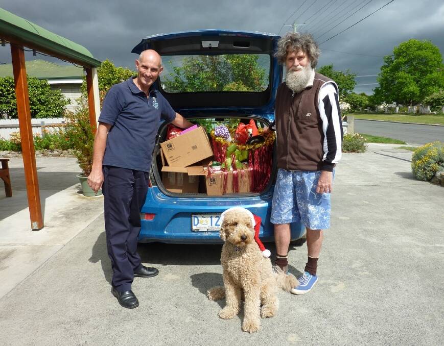CHRISTMAS MISSION: East Coast Vet Clinic's Jeff Parsons and Anglicare's Thom Ryan prepare to deliver Christmas hampers as campaign mascot Savanna looks on. Donations can be made at the clinic or at Bicheno Post Office. 