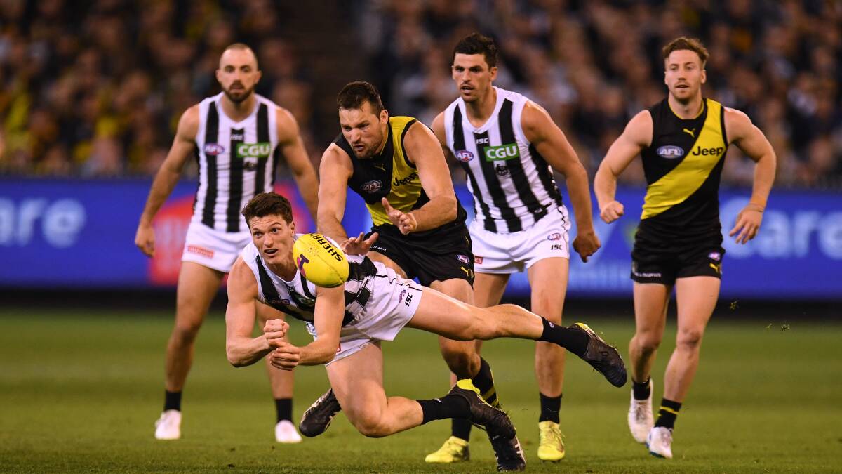 MIHOCEK THIS OUT: Brody Mihocek fires out a handball under pressure from fellow Tasmanian Toby Nankervis in Collingwood's preliminary final win over Richmond. Picture: AAP