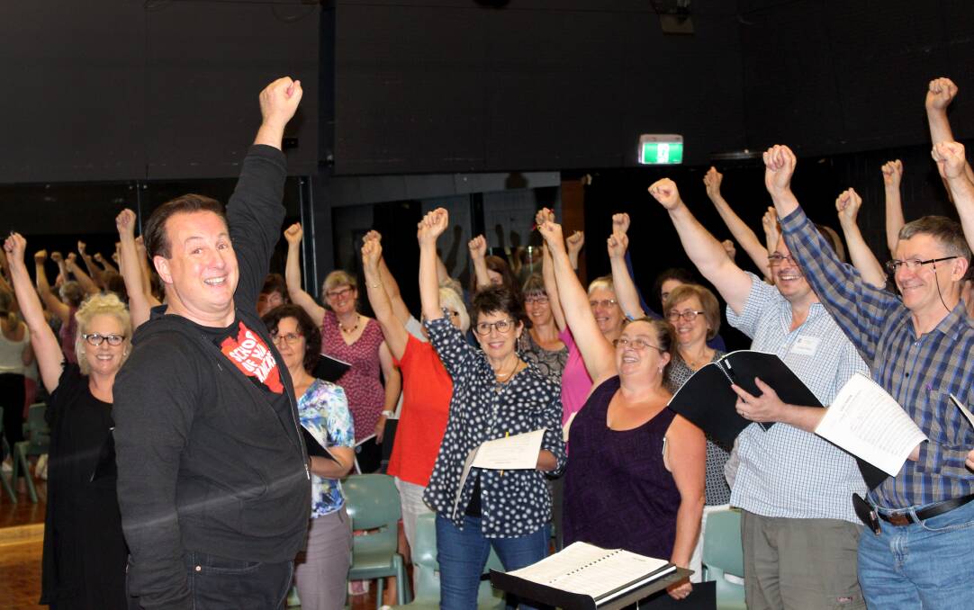 UP AND AWAY: Choir of Hard Knocks director Jonathon Welch takes Vox Harmony through its paces ahead of a performance of Street Requiem at Door of Hope in April. Pictures: Hamish Geale 