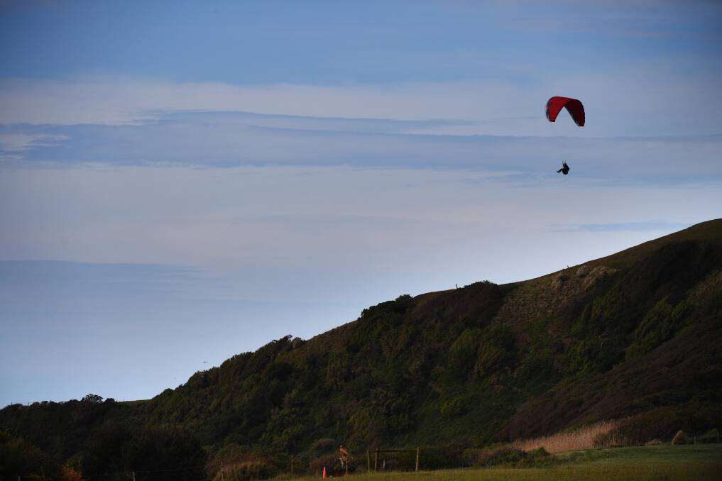 UP WITH THE BIRDS: A paraglider floats over the hills near Lillico beach on the state's North-West Coast. Picture: Scott Gelston. 