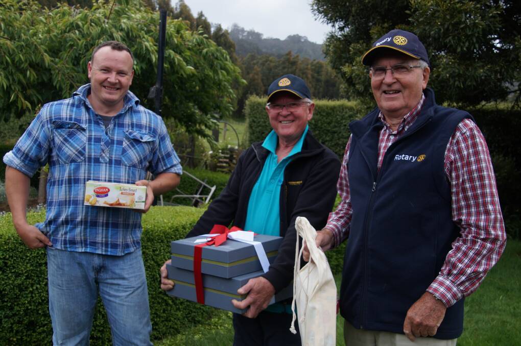 GOOD CHEER: Liena resident Duncan How receives a Christmas hamper from Deloraine Rotary Club president Bill Muldoon and former Rotary Tasmania district governor John Dare. Picture: Supplied