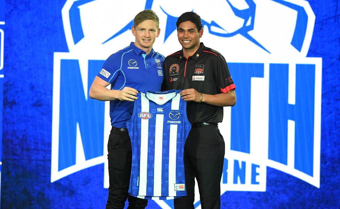 NEW ROO: Tasmanian Tarryn Thomas receives a North Melbourne guernsey from Jack Ziebell. Picture: AAP