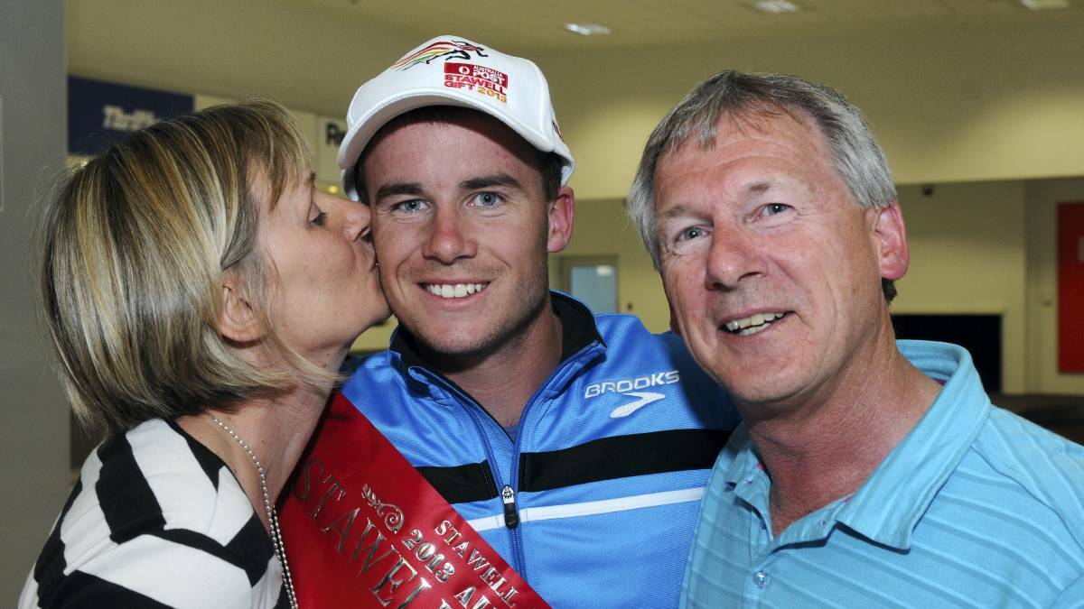VICTORY: Launceston sprinter Andrew Robinson celebrates winning the Stawell Gift with parents Cyndi and Steve in 2013. Picture: Supplied