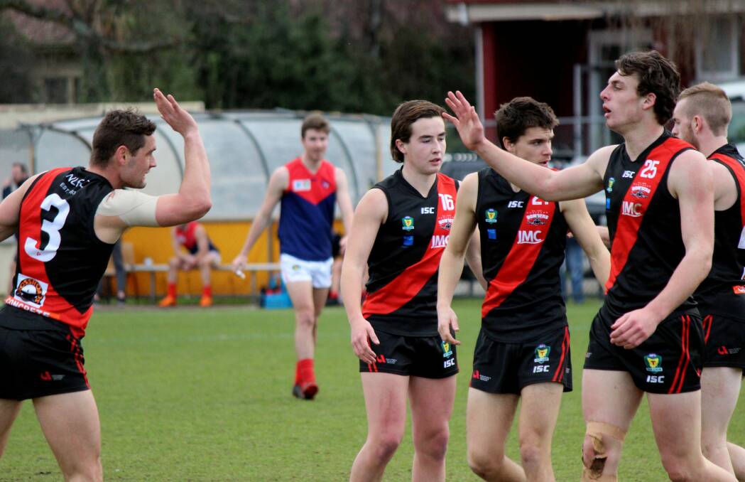 TEAMMATES: Former North Launceston coach Taylor Whitford shares a high-five with Jackson Callow. 