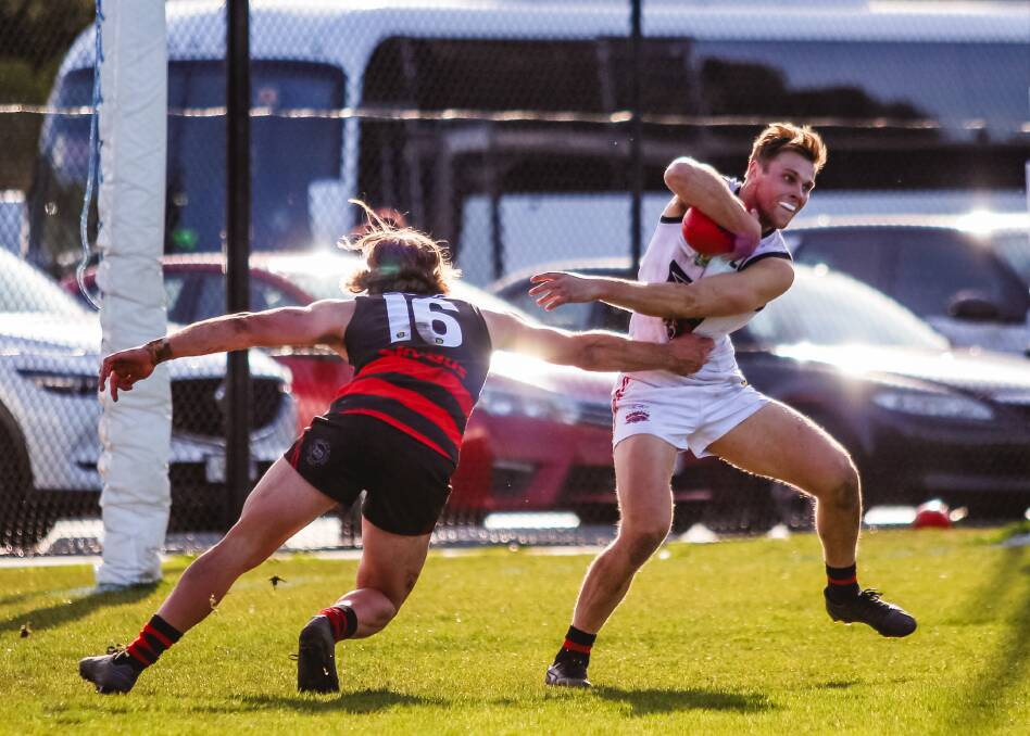 SLIPPERY. North Launceston gun Jay Foon swivels out of a tackle from Lauderdale's Nathan Oakes. Pictures: Kristi Mead 