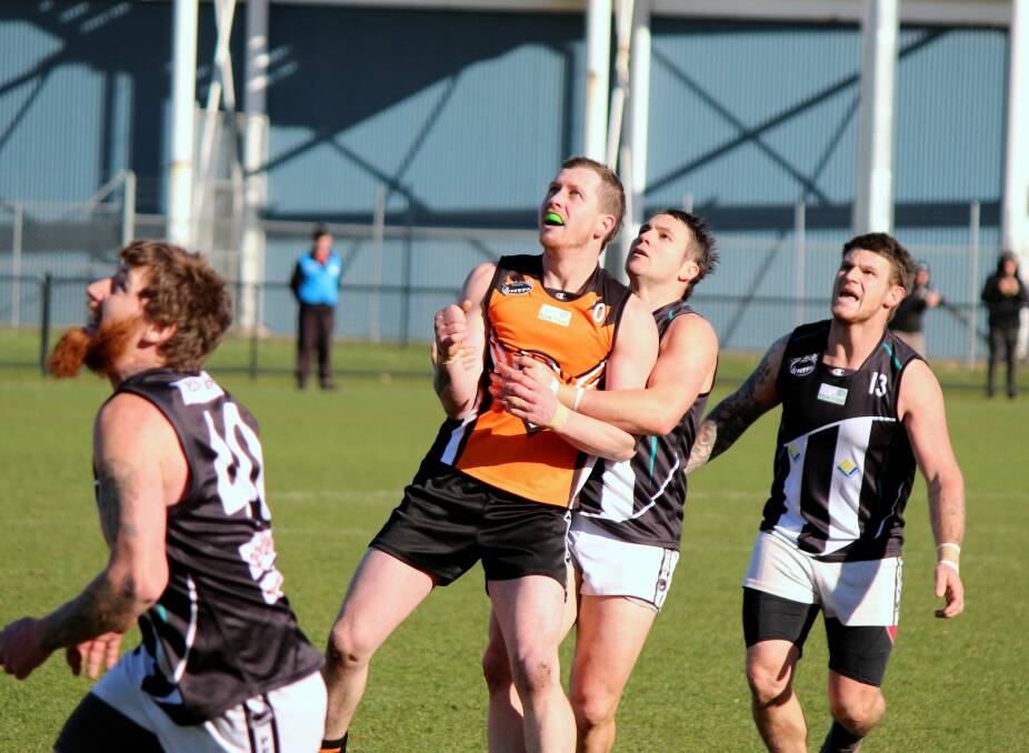THERE IT GOES: Magpie Ethan Jackson arrives fractionally too late to stop East Coast star Michael Musicka kicking a goal. Picture: Hamish Geale 