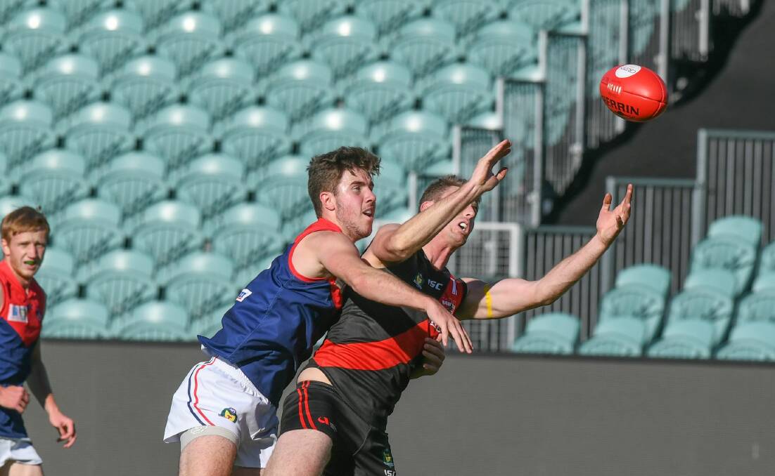 MISSING: Young defender Bailey Walker spoils North Launceston forward Bart McCulloch. 
