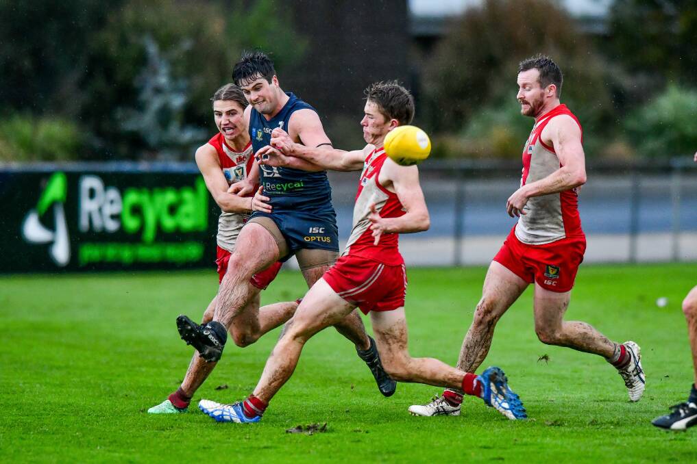 SWAMPED: Blues ball magnet Fletcher Seymour soccers away from a pack of ex-teammates. Saturday's clash is set to be another sodden affair.