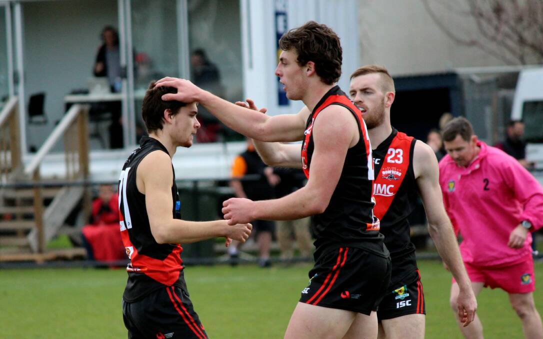 JOB WELL DONE: Northern Bombers forward Sherrin Egger receives back-to-back hair tousles from teammates Jackson Callow and Josh Ponting. Pictures: Hamish Geale