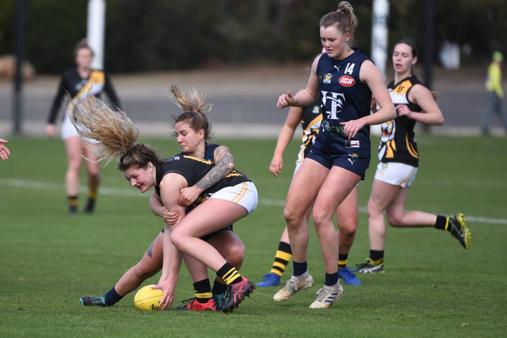 PINNED: Launceston midfielder Claire McManus lays a tackle on Tiger Maci Polley as ruck Camilla Taylor arrives in support. Pictures: Paul Scambler 