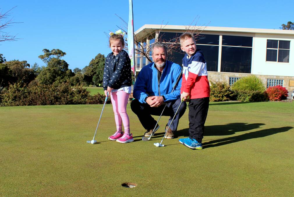 HOLE LOT OF FUN: Riverside Golf Club professional Michael Swan gives some tips to six year-old duo Indie Holland, of Riverside, and Louie Orpwood, of West Launceston. Picture: Hamish Geale