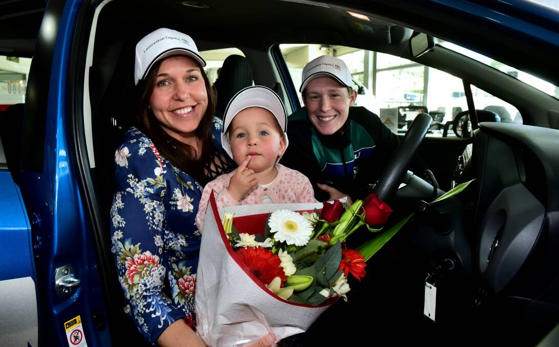 HAPPY FACES: Toyota Local Sporting Legends competition winners Renee Marshall with baby Evie, 2, and Zack Gilmore in their new car. Picture: Neil Richardson