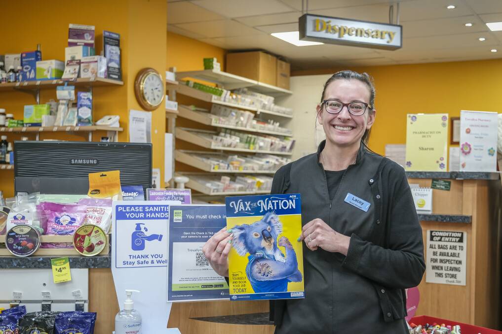 GET VACCINATED: Trevallyn Pharmacy retail manager Lacey Walsh with The Examiner's Vax-The-Nation poster . Picture: Craig George