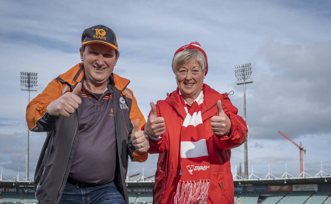 Swans supporter Margret Price and Giants supporter Rick De Sousa. Picture: Craig George 