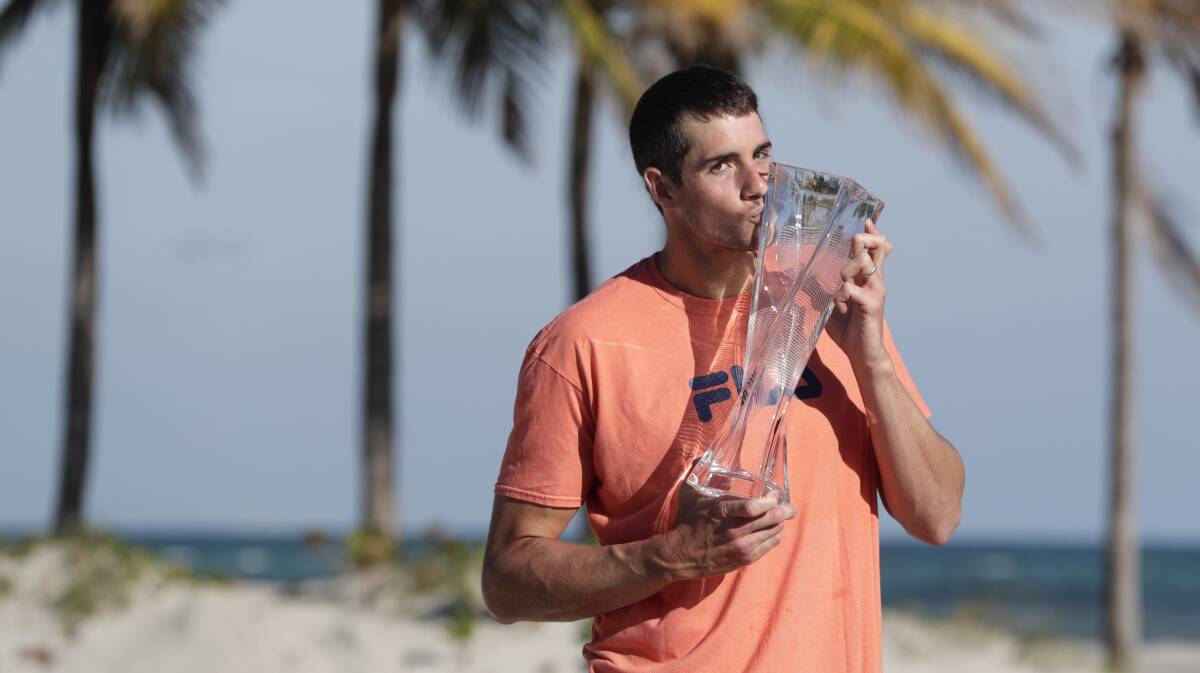 SWEET VICTORY: John Isner, coached by Tasmanian David Macpherson, poses with his trophy on Crandon Park Beach, after defeating Alexander Zverev in the men's final at the Miami Open on Sunday. Picture: AP 