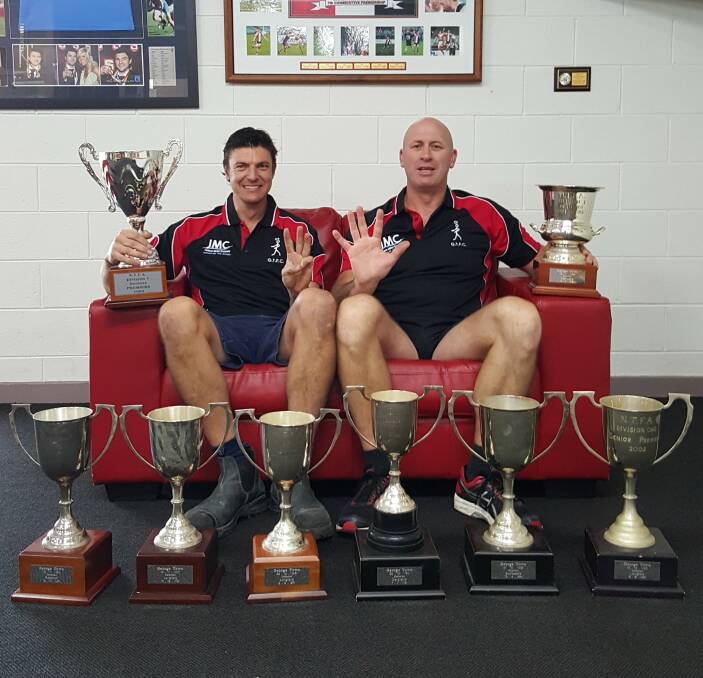 CHAMPIONS: George Town premiership coaches Anthony Axton and Dale Chugg with the club's eight consecutive NTFA cups won between 2002 and 2009.