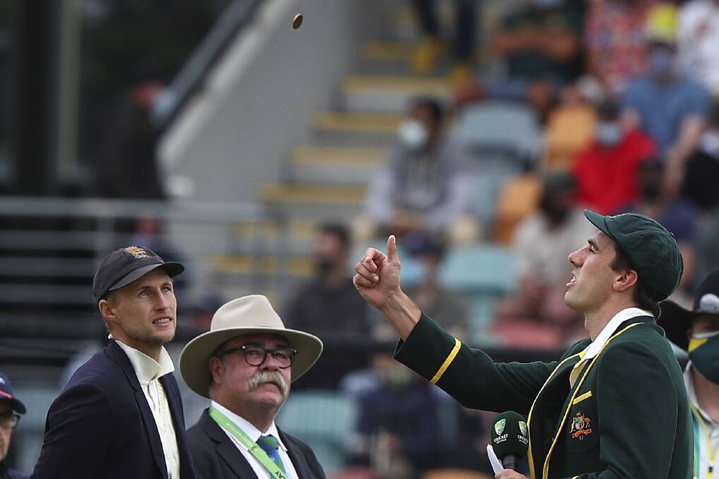 HISTORY: England captain Joe Root and Tasmanian match referee David Boon watch as Australian skipper Pat Cummins tosses the coin before the start of the match. Picture: AP