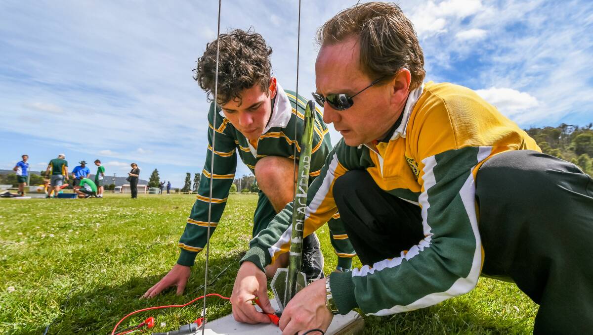AIM HIGH: Science teacher Jacob Williard helps to prepare a rocket for firing. Picture: Phillip Biggs