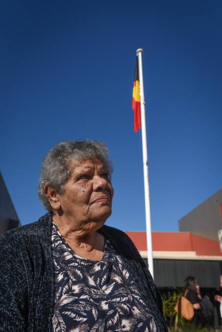 UNITY: Aboriginal Elder Aunty Dorothy Murray raises the flag. Picture: Paul Scambler