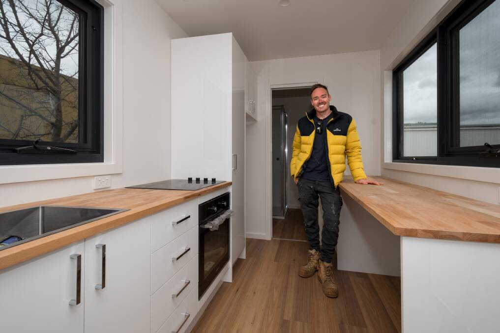 Jason Zadow in the "full size kitchen" of his 40ft shipping container conversion. Picture by Phillip Biggs