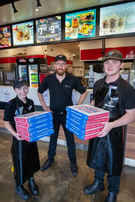 PIECE OF THE PIE: Mark Johnson (middle) with employees Montanah Roney (left) and Alex Vandenberg at the Kings Meadows Domino's store. Picture: Paul Scambler