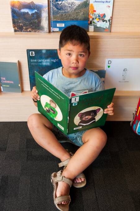 Quiet time: Four-year-old Liam Janssen discovers a new book at the Launceston library. Picture: Phillip Biggs