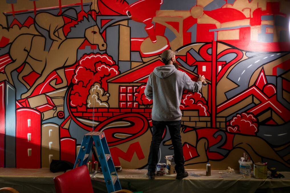 Graffiti artist Conrad Bizjek creating a piece on the wall of Mowbrew Cafe at Mowbray. Picture: Phillip Biggs