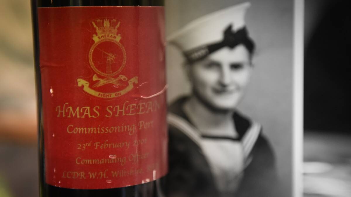 The bottle of port presented to Garry Ivory, with a portrait of Teddy Sheean in the background. Picture: Paul Scambler