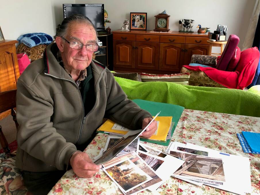DEVOTED: Col Bailey, at home in New Norfolk, pores over photos and documents relating to Churchill's Hut. Picture: Rob Inglis