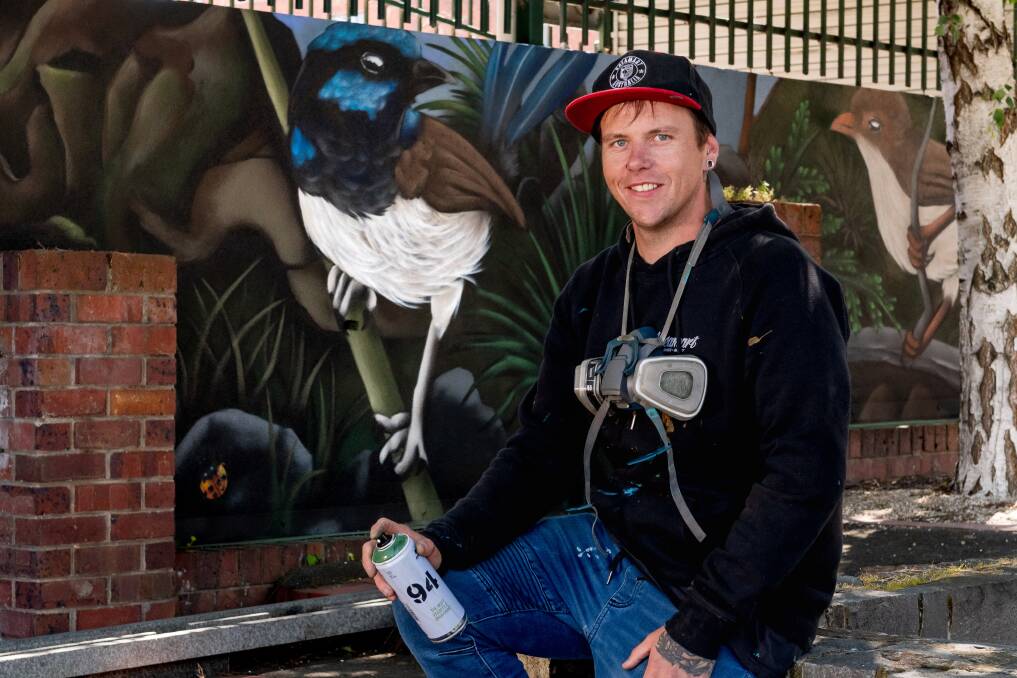 Graffiti artist James Cowan with posing with his street mural in Launceston. The mural is located at the intersection of York Street and George Street. Picture by Phillip Biggs. 