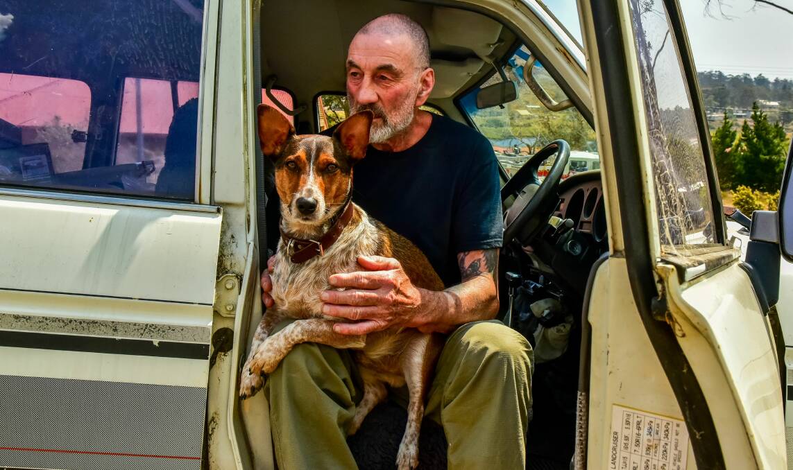 Getting out: Ron Camm prepares to evacuate with his dog Boots. Picture: Neil Richardson. 