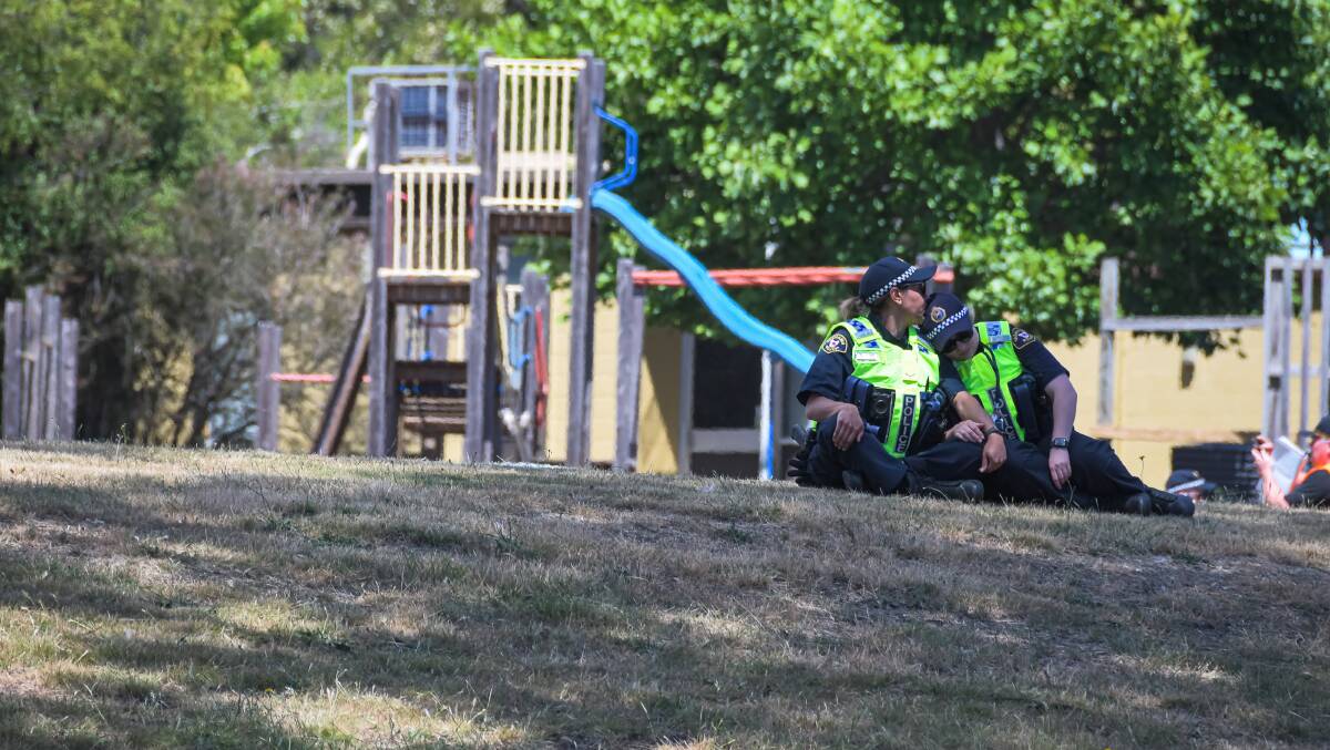 Heartbroken: Two police officers console each other in the grounds at Hillcrest Primary. Picture: Simon Sturzaker.