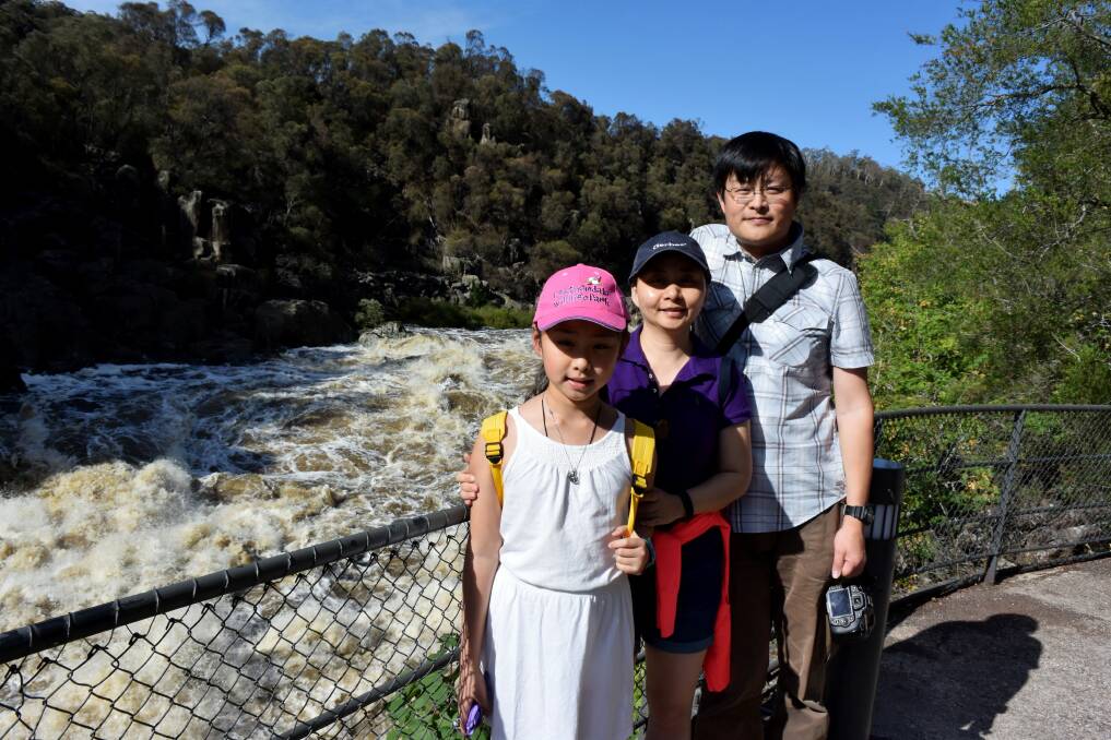 VISITING: Tourists Jane Xu, Joe Yan and daughter Joanne Yan, 9, of China, visit the Cataract Gorge in flood. Picture: File 
