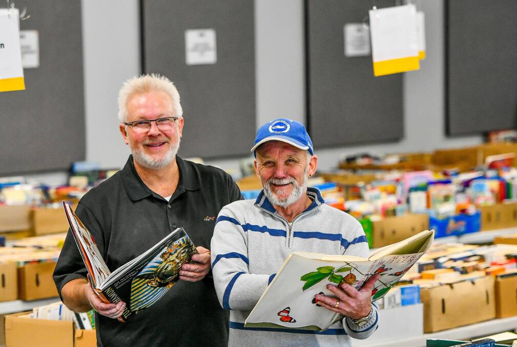 GOOD BOOKS: Volunteers Rod Spinks and Freddie Todman catch up on some light reading ahead of City Mission's annual Bookfest, beginning Friday. Picture: Scott Gelston
