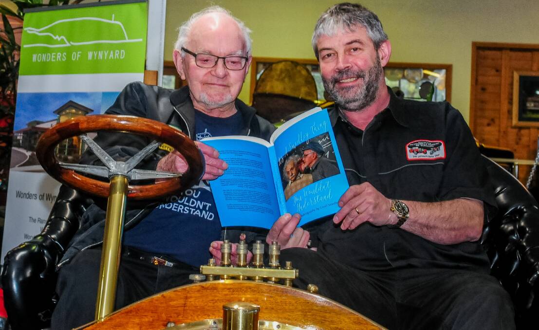 IT'S A SMEDLEY THING: Geoff Smedley and Phillip Costello flick through Geoff's autobiography at the National Automobile Museum of Tasmania. Picture: Neil Richardson