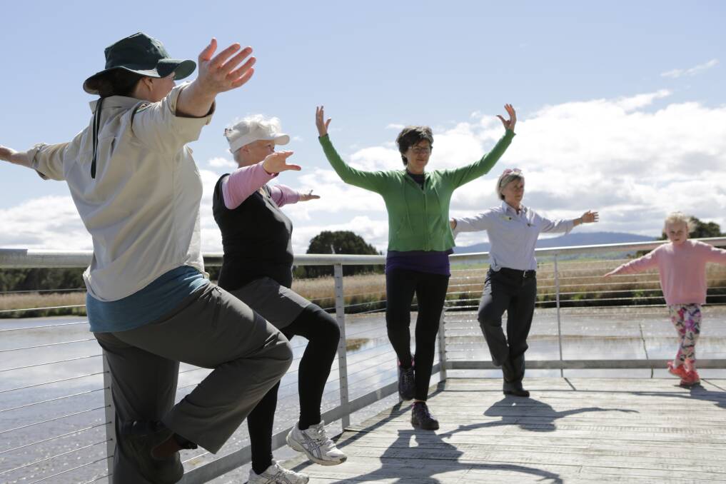 Tracey-Ann Hooley, Lee Ponting, Diana Trapp, Sophie King and Lottie Smith, 7, practice some yoga on the deck of the Tamar Islands Wetland Centre. Picture: Matt Dennien