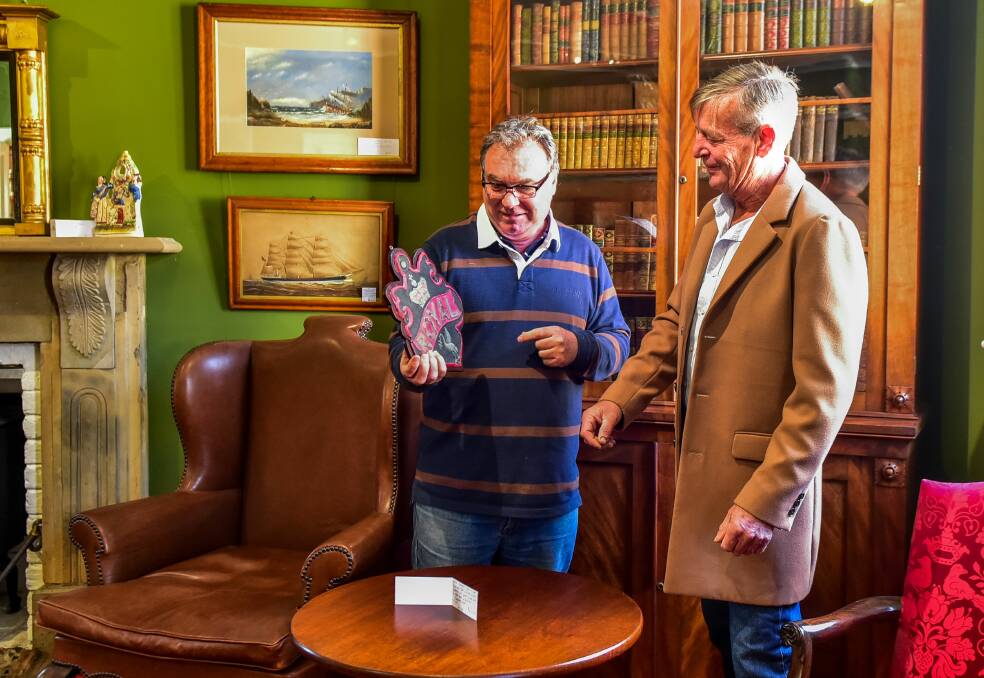 Tasmanian Antiques Fair coordinators James Abbott and Peter Woof with a plaque used to show buildings were insured. Picture: Neil Richardson 